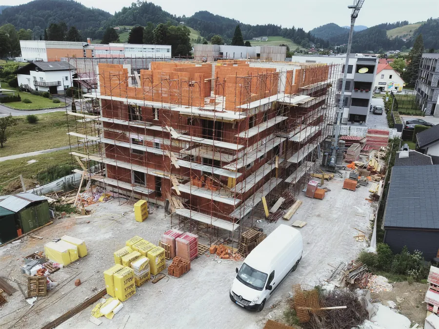 Večstanovanjski objekt v gradnji z opečnimi zidovi in odri, pogled z drona